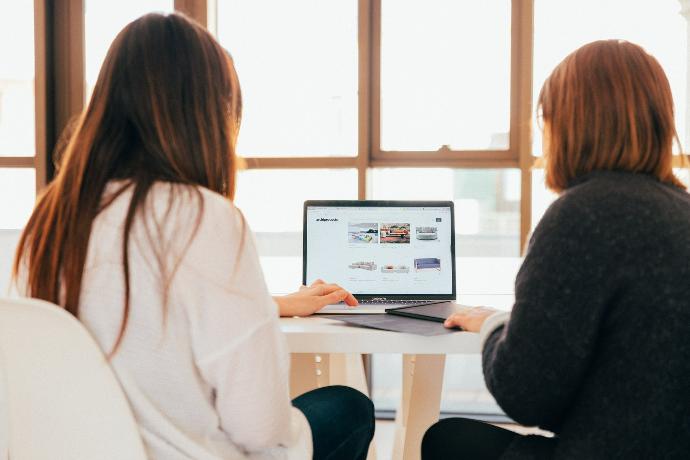 <h3 class="card-title" style="color: rgb(102, 102, 102);"><font style="vertical-align: inherit;">Transparency</font></h3> two women talking while looking at laptop computer